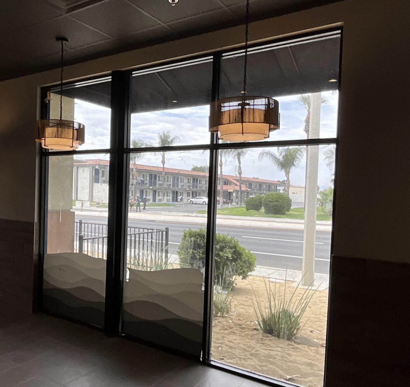 Restaurant windows and roller shades before the upper-pane window-film installation.