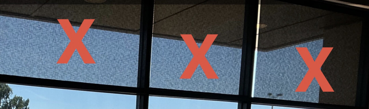 Upper storefront panes marked with red Xs in a before-project photo.