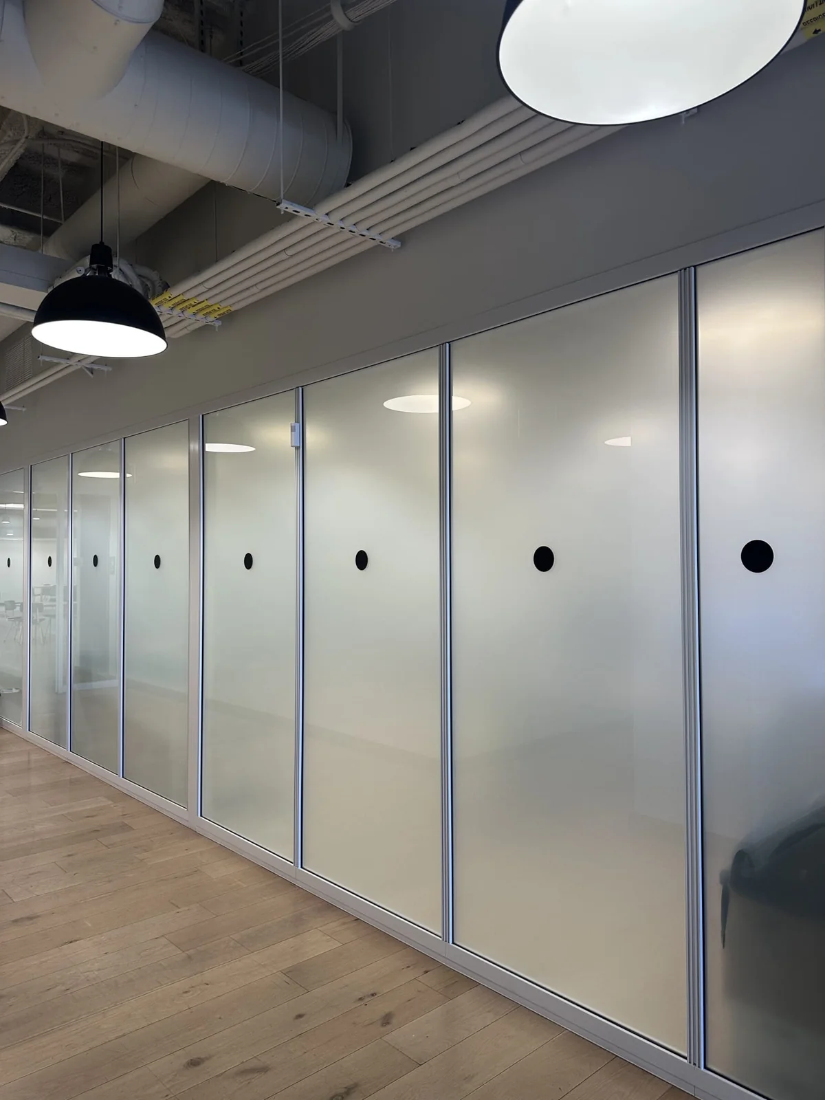 Frosted glass office partitions beneath pendant lights